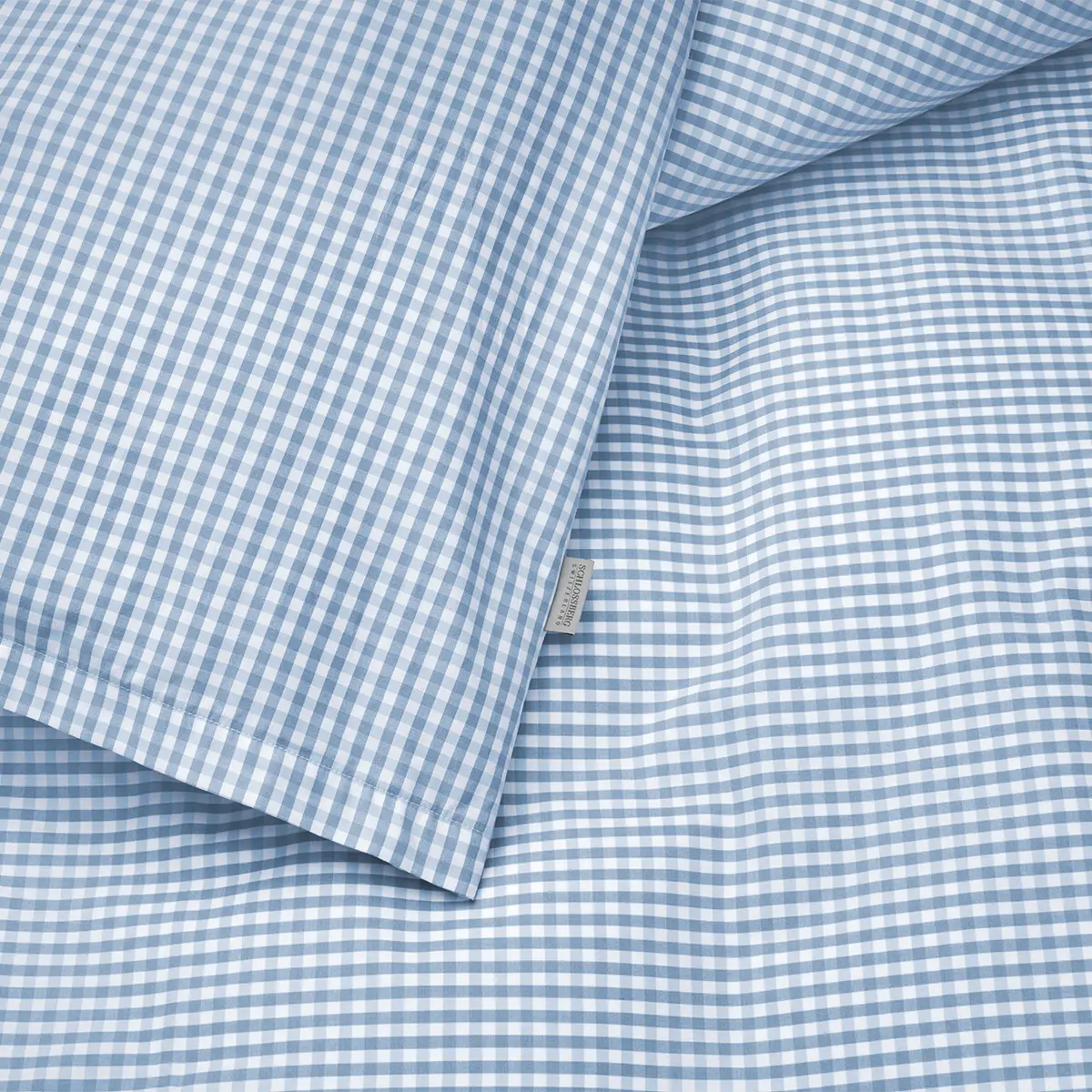 Detailaufnahme der Schlossberg Bettwäsche Andrin in Blau mit einem feinen Karomuster. Die hochwertige Baumwolle bietet einen angenehmen Komfort und eine weiche Textur, ideal für eine entspannte Nachtruhe.