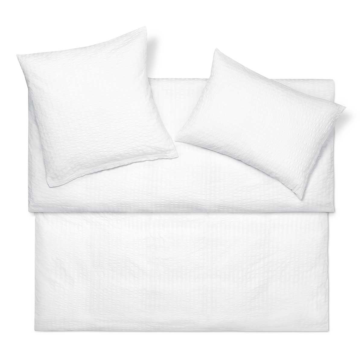 Set aus weisser Bettwäsche Dean mit gestepptem Design, bestehend aus einem Kissenbezug und einem Bettbezug, auf einem weissen Hintergrund arrangiert.