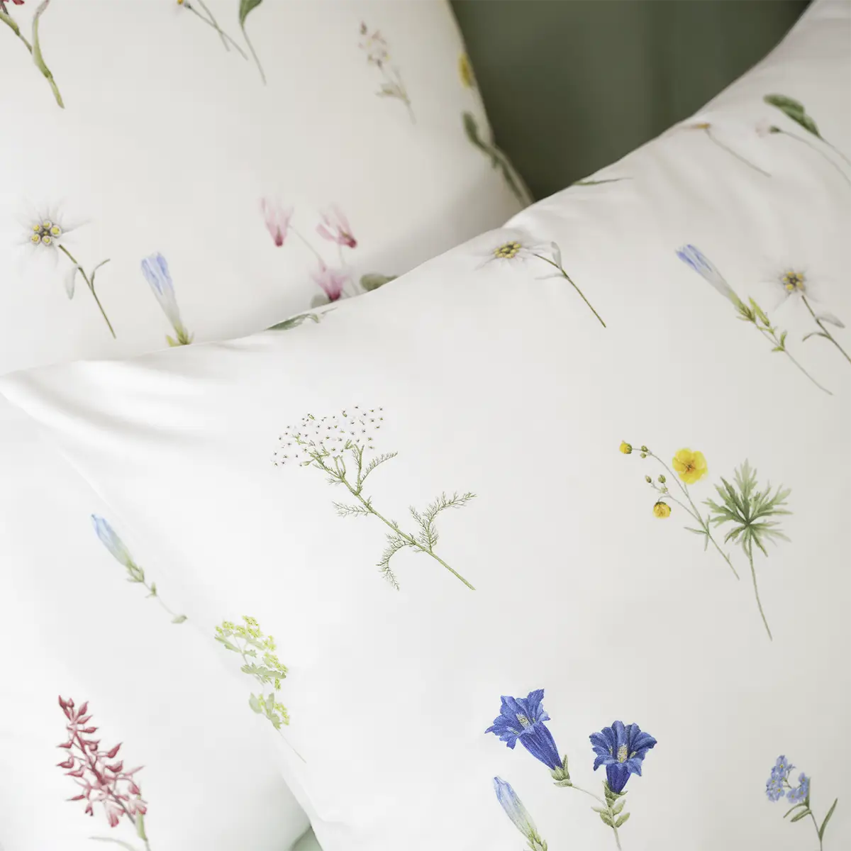 Kopfkissen mit Blumenmuster - Bettwäsche "Flurina" Nahaufnahme von Kopfkissen, die Teil der weissen Bettwäsche "Flurina" mit einem dezenten Blumenmuster sind.
