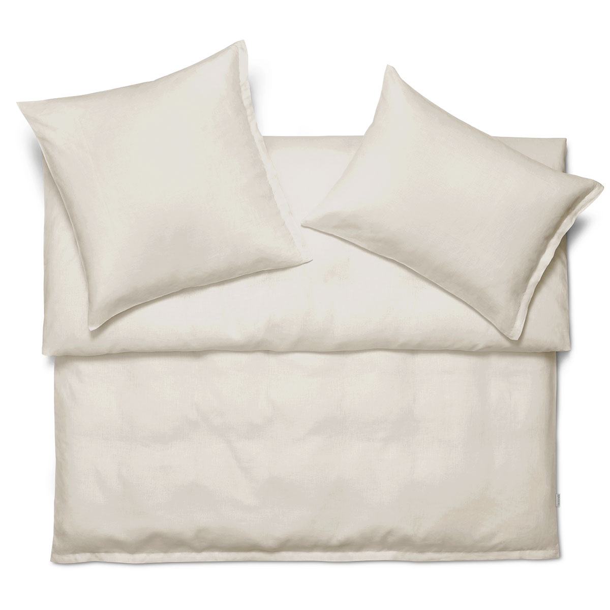 Bettwäsche Mira in schlichtem Crème, bestehend aus einem Duvetbezug und zwei Kissenbezügen, auf einem Bett arrangiert.