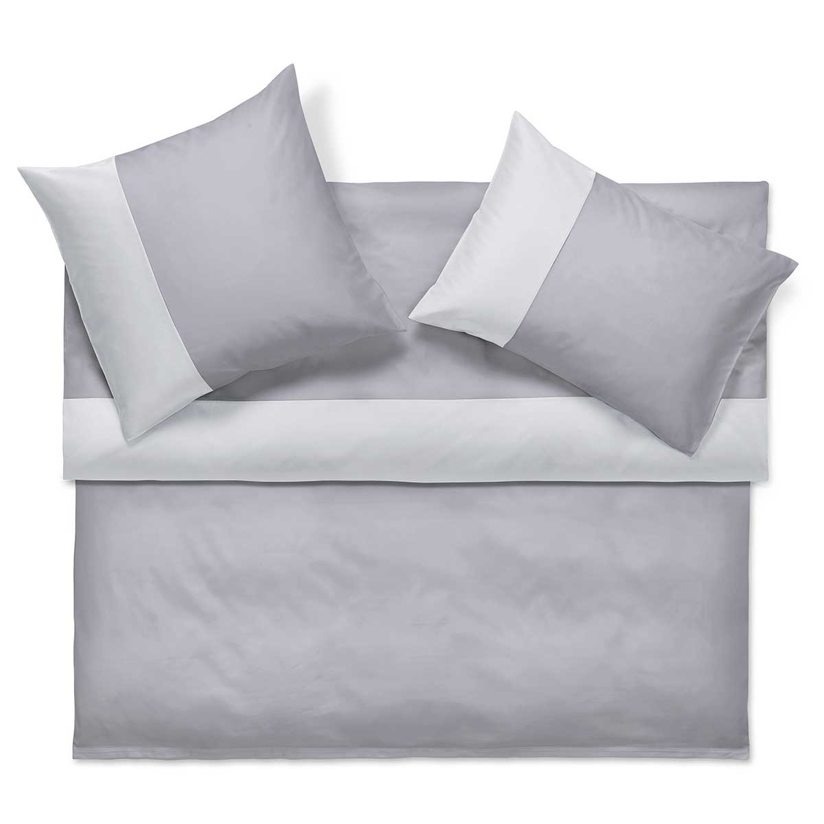 Ein Bett mit grauer Bettwäsche und zwei passenden grauen Kissen mit weissen Akzenten. Die Bettwäsche ist ordentlich auf einem weissen Hintergrund arrangiert.