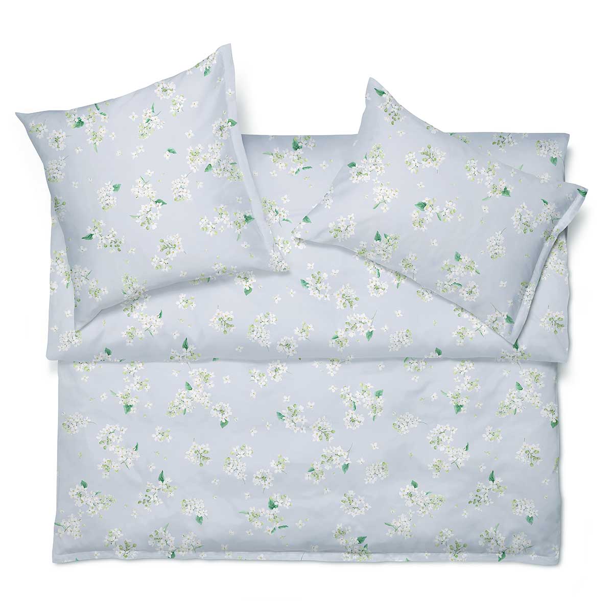 Bettwäsche May in Blau mit Blumenmuster Die Bettwäsche May in Blau mit einem zarten Blumenmuster, perfekt arrangiert auf einem Bett für ein frisches und einladendes Ambiente.