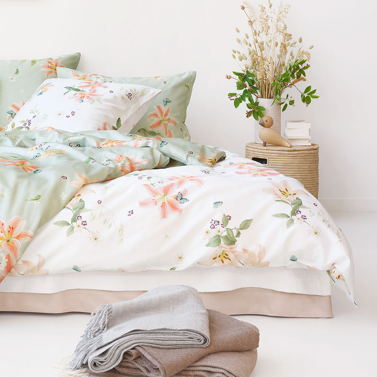 Lilian Bettwäsche in floralem Design auf einem Bett Bettwäsche Lilian mit Blumenmuster in zarten Pastellfarben, dekoriert auf einem Bett in einem hellen Raum.