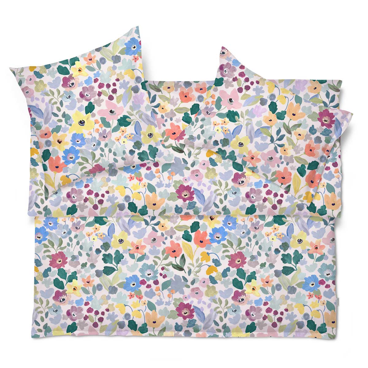Die Bettwäsche "Hanna" mit buntem Blumenmuster, komplett auf einem Bett arrangiert.