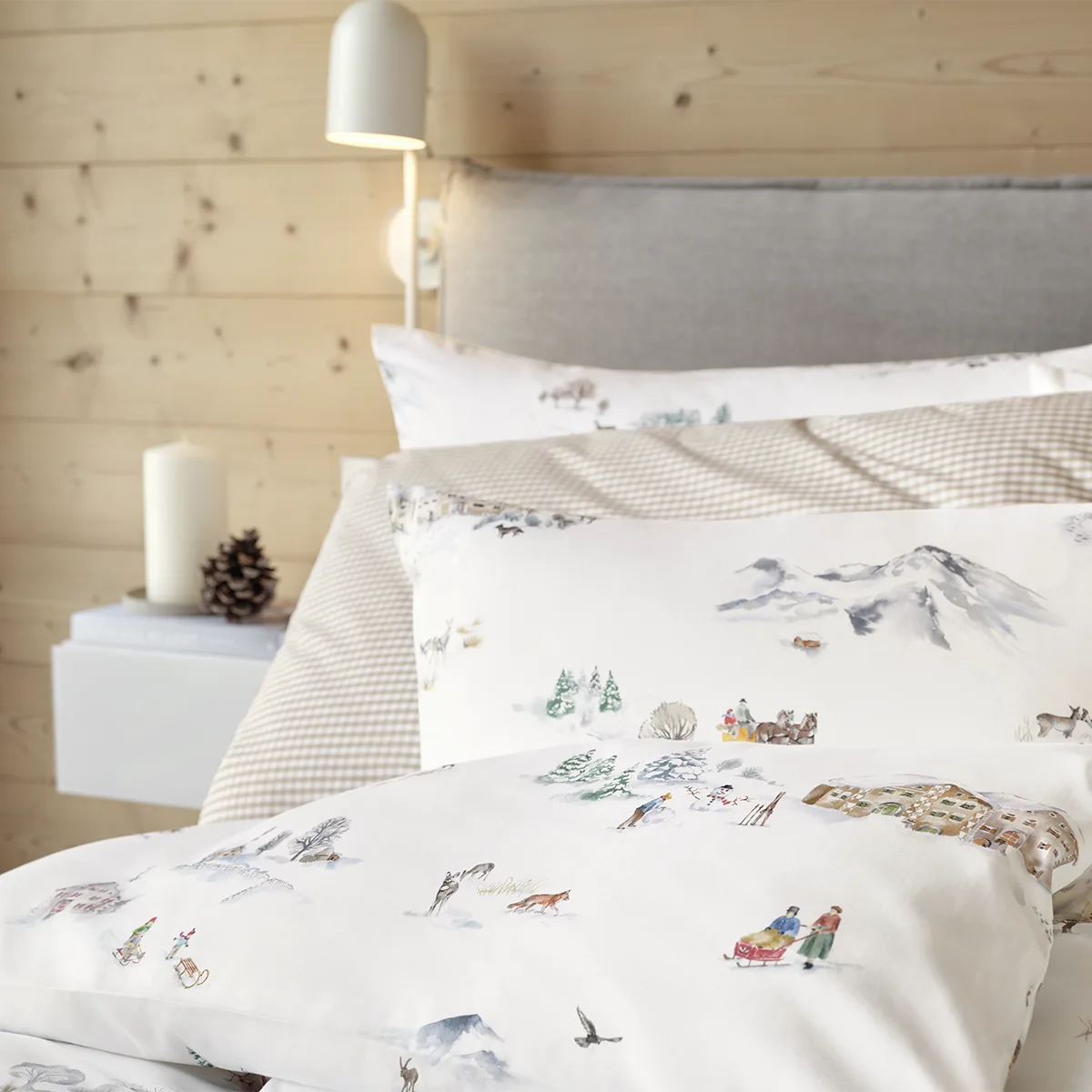 Gemütliches Schlafzimmer mit Montagne Bettwäsche Schlafzimmer in einer Holzstube, das Bett ist mit der Montagne Bettwäsche in einem alpinen Winterdesign bezogen.