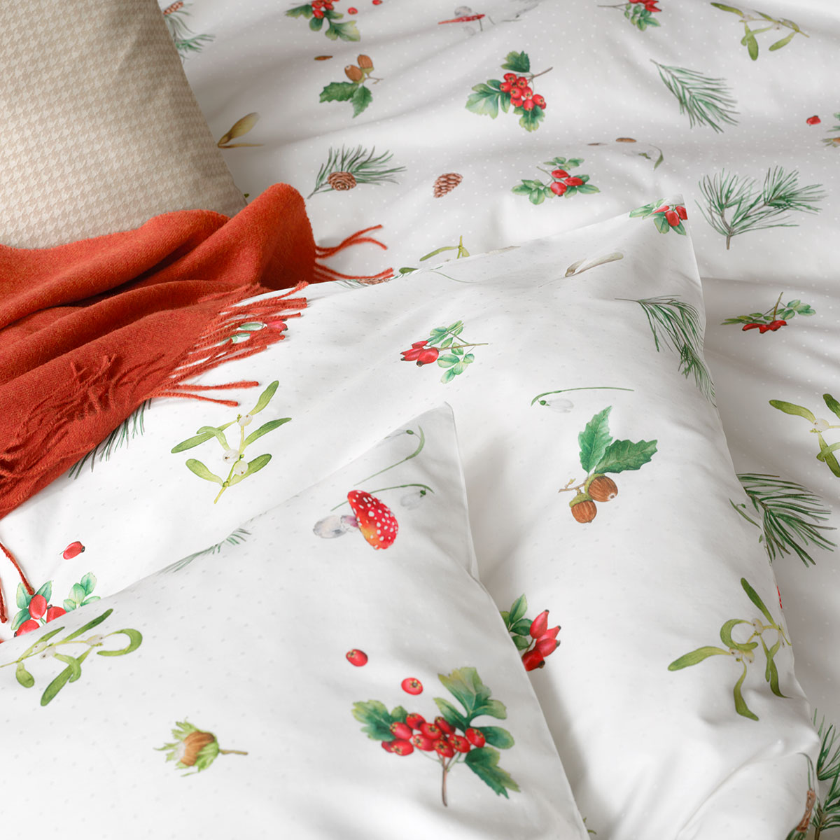 Gemütlich eingerichtetes Schlafzimmer mit der Hazel-Bettwäsche, dekoriert mit einer roten Decke und einem beigen Kissen.