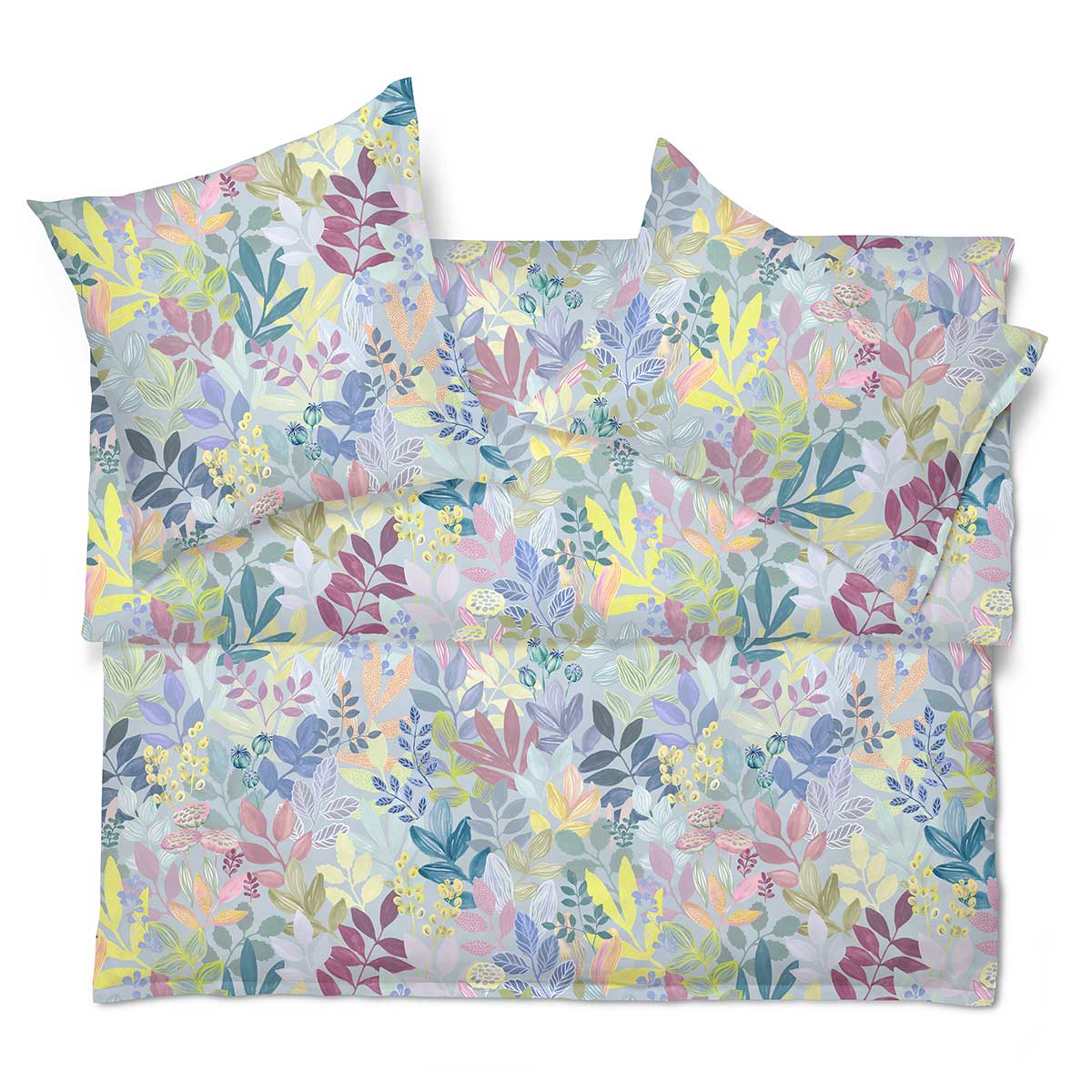 Bunte Bettwäsche "Frida" mit einem verspielten Blättermuster, gezeigt in Draufsicht mit zwei Kopfkissen und Bettdecke.