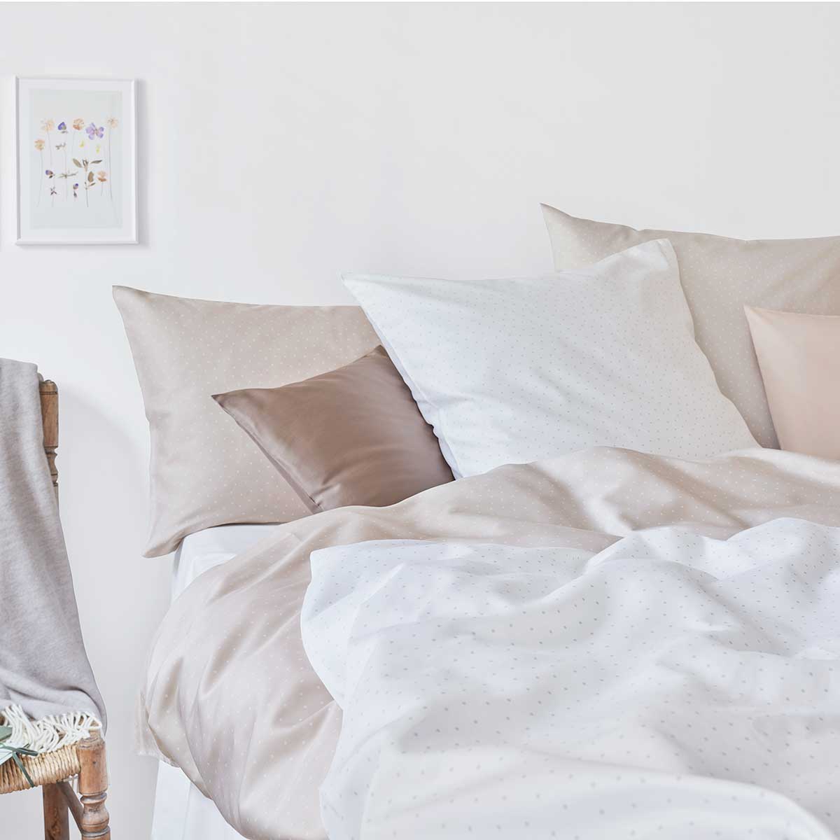 Bettwäsche Emily im Schlafzimmer Ein Bett im Schlafzimmer, bezogen mit verschiedenen Farben der Bettwäsche Emily, darunter Beige und Weiss.