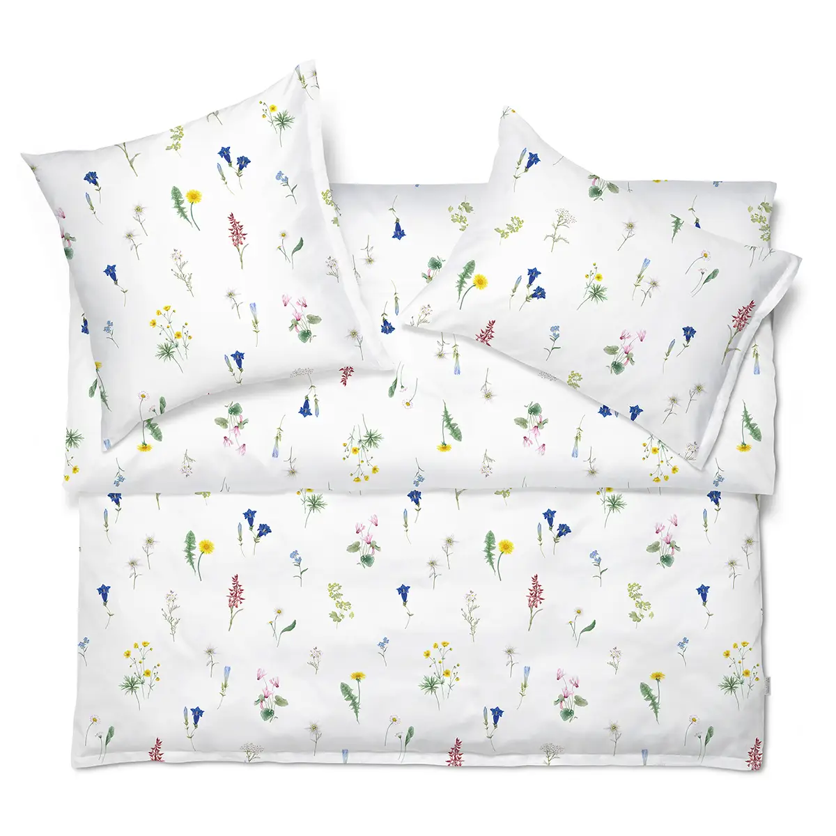 Weisse Bettwäsche "Flurina" mit floralem Design - Draufsicht Weisse Bettwäsche "Flurina" mit einem floralen Design, gezeigt in Draufsicht mit zwei Kopfkissen und Bettdecke.